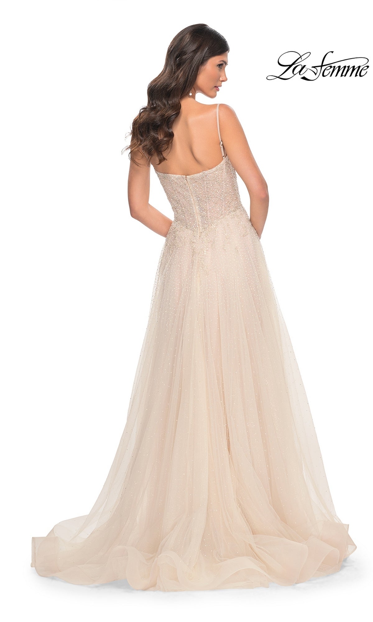 Woman in a champagne La Femme 32271 long A-line prom dress with spaghetti straps and a flowing tulle skirt, shown from the back against a white backdrop.